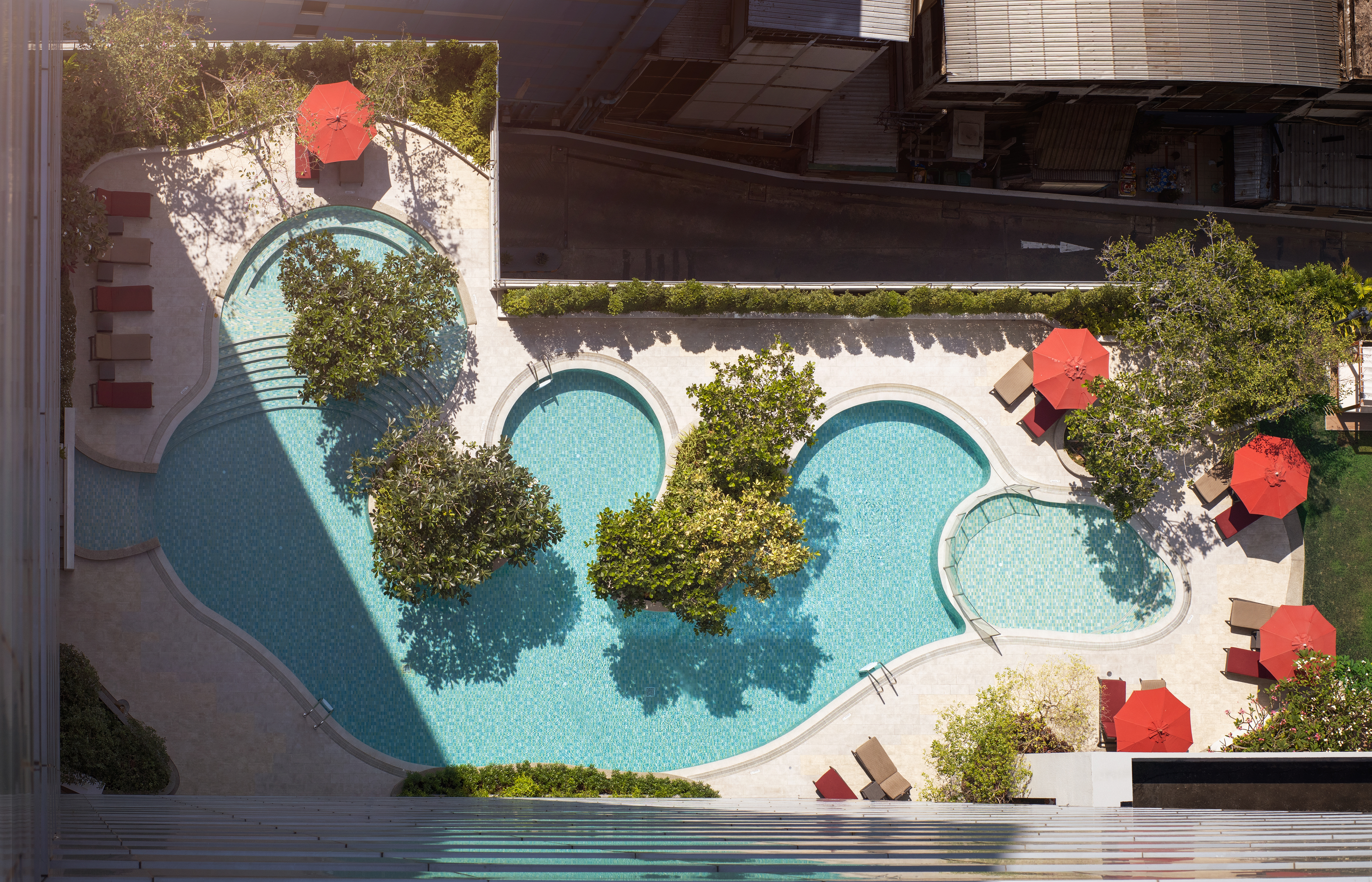 Overhead view of the free-form pools and sundeck at Amari Bangkok