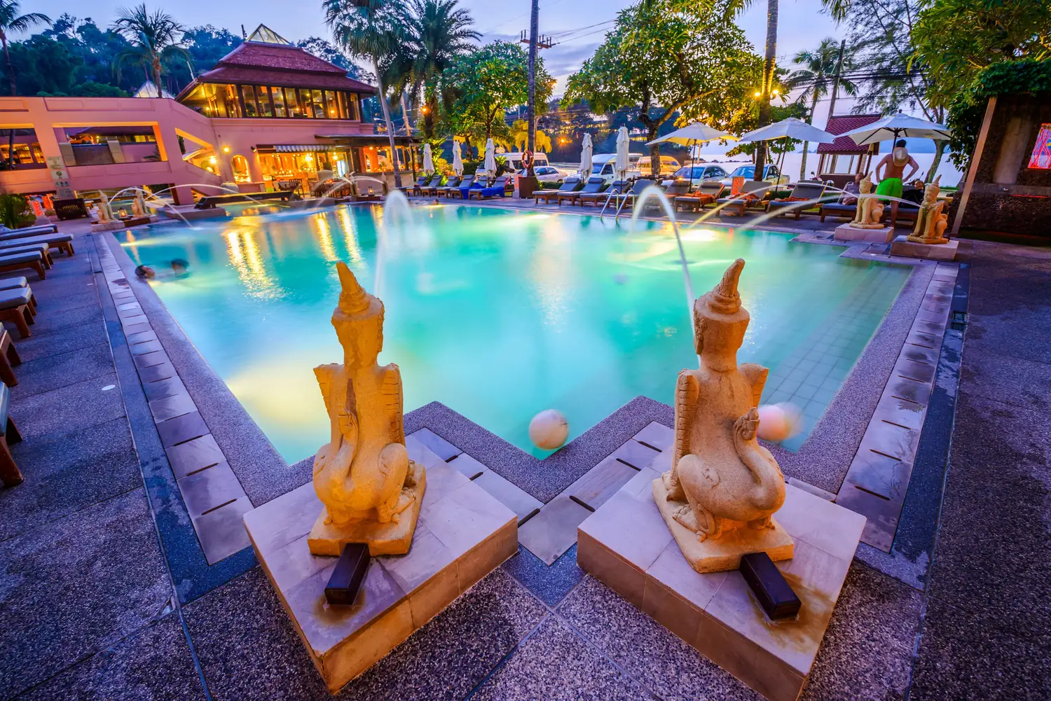 Illuminated pool and fountains at dusk