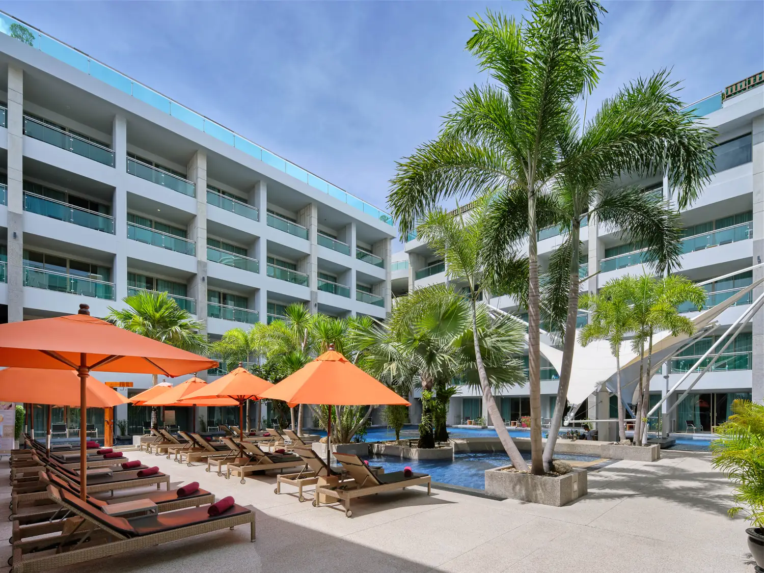 Pool courtyard with loungers and orange parasols